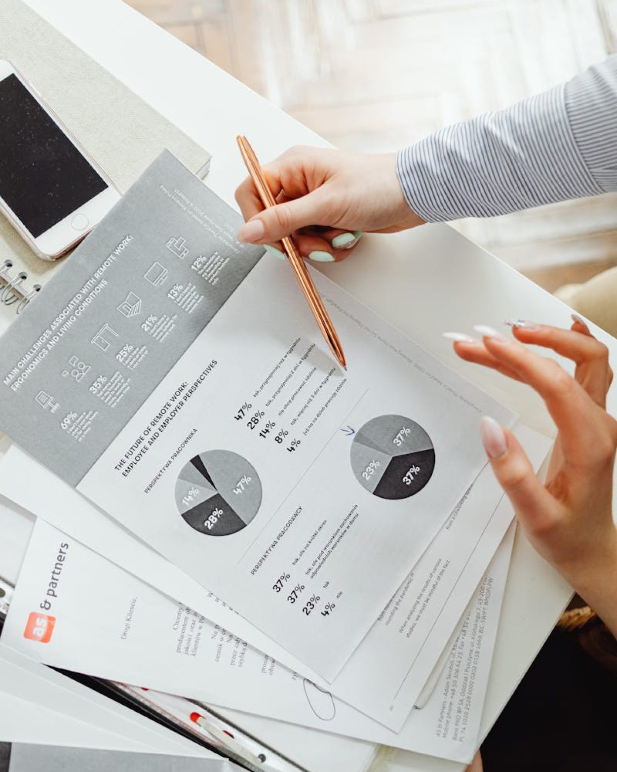 Close-up of businesswoman analyzing financial reports using pie charts in an office setting.